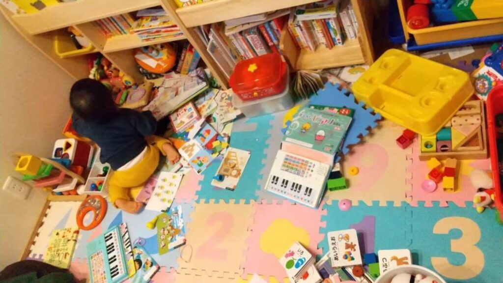 遊びの途中に本を見ている幼児